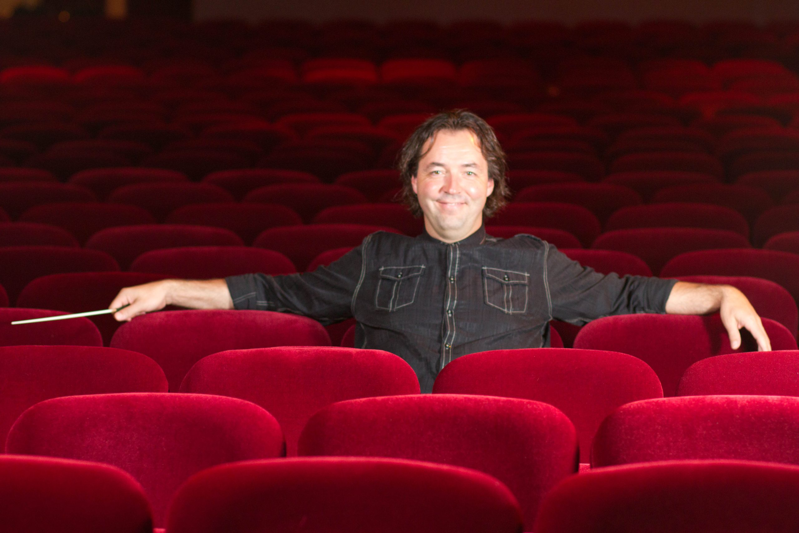 Conductor Bohuslav Rattay sitting in seats at the Plaza Theater